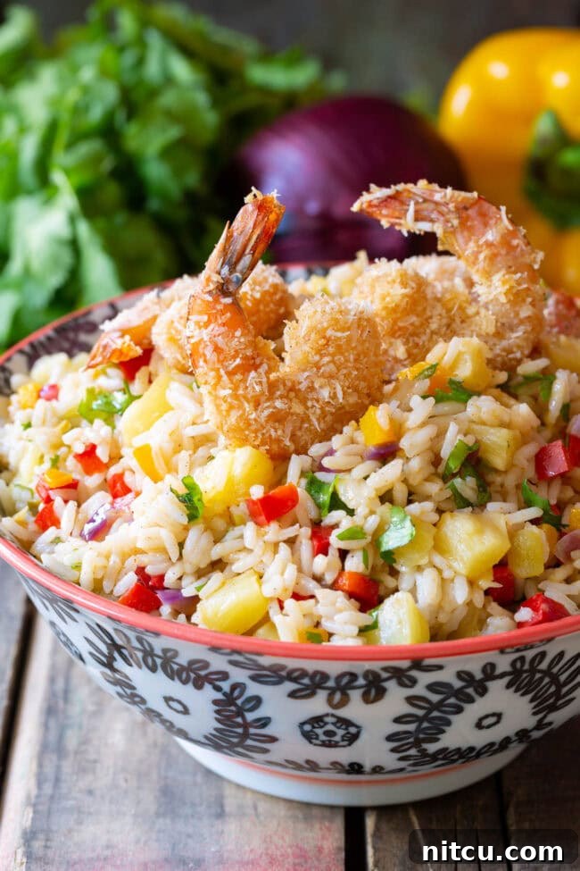 Caribbean Rice in a bowl with coconut shrimp on top.