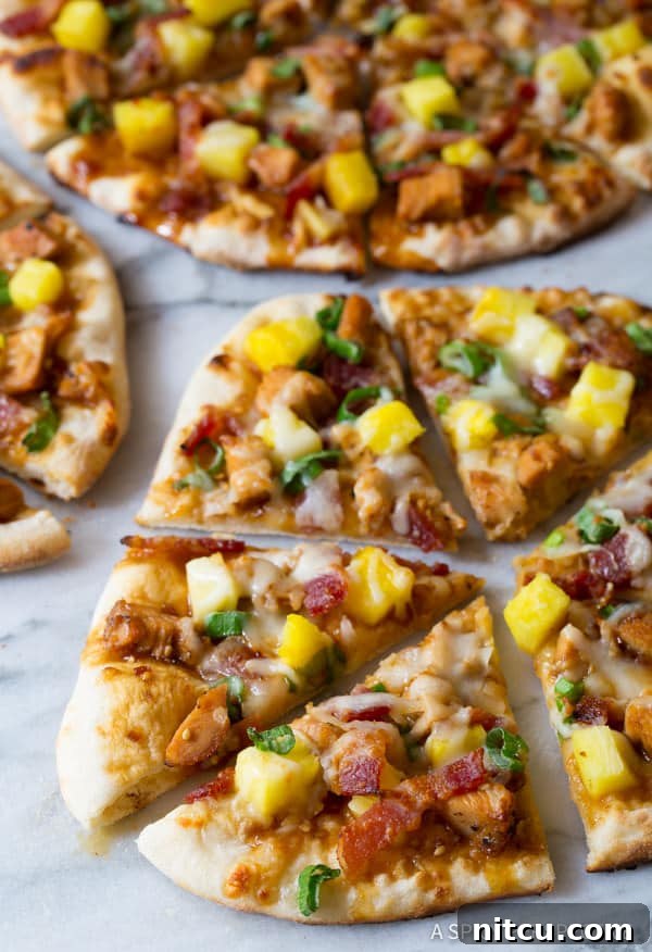 Teriyaki Pizza close up of pizza slices with chicken, pineapple, and melted cheese, ready to be eaten.