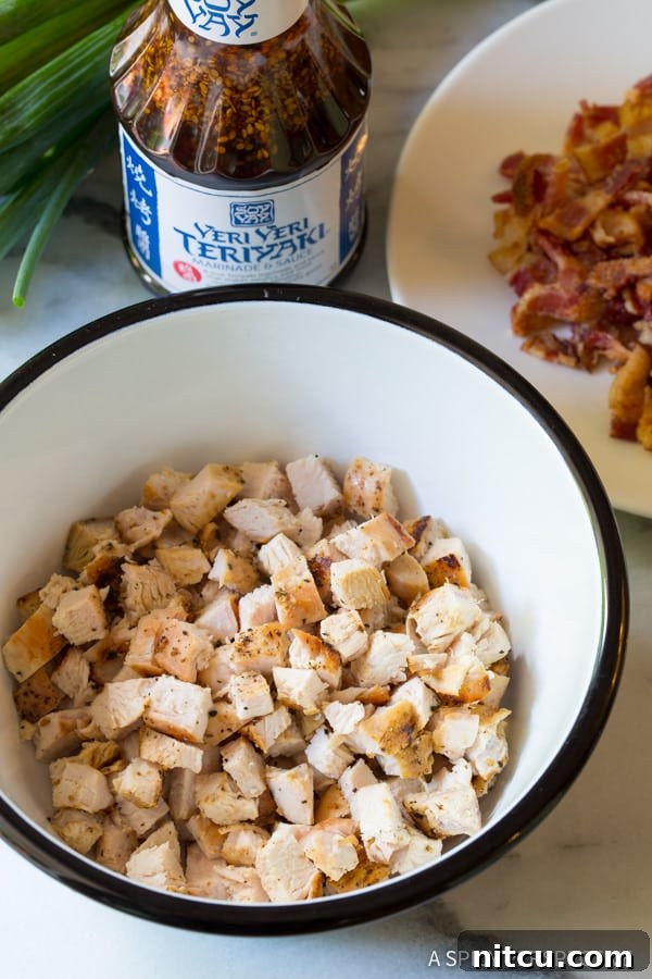 Bowl full of cooked grilled chicken that is chopped into pieces.