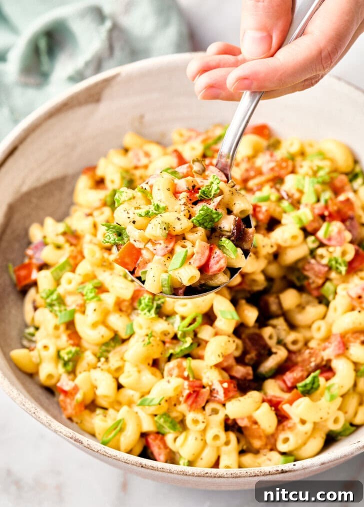 Best Macaroni Salad Recipe with spoon lifting salad out of bowl