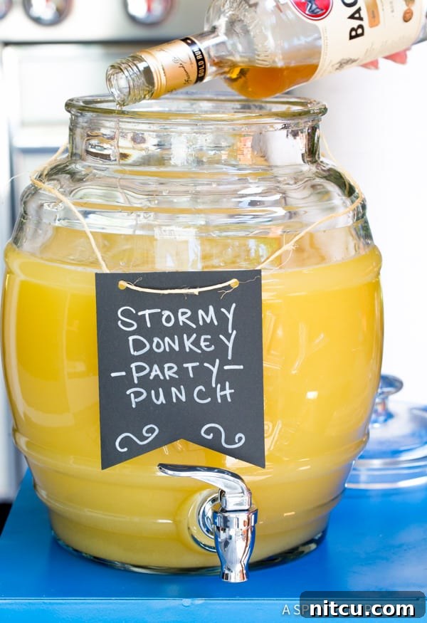 Mixing the ingredients for Stormy Donkey Party Punch in a large beverage dispenser, ready for a party.