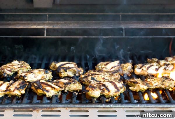 Jerk Chicken Thighs cooking on an outdoor grill