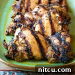 Jerk Chicken Thighs on a plate with a drink