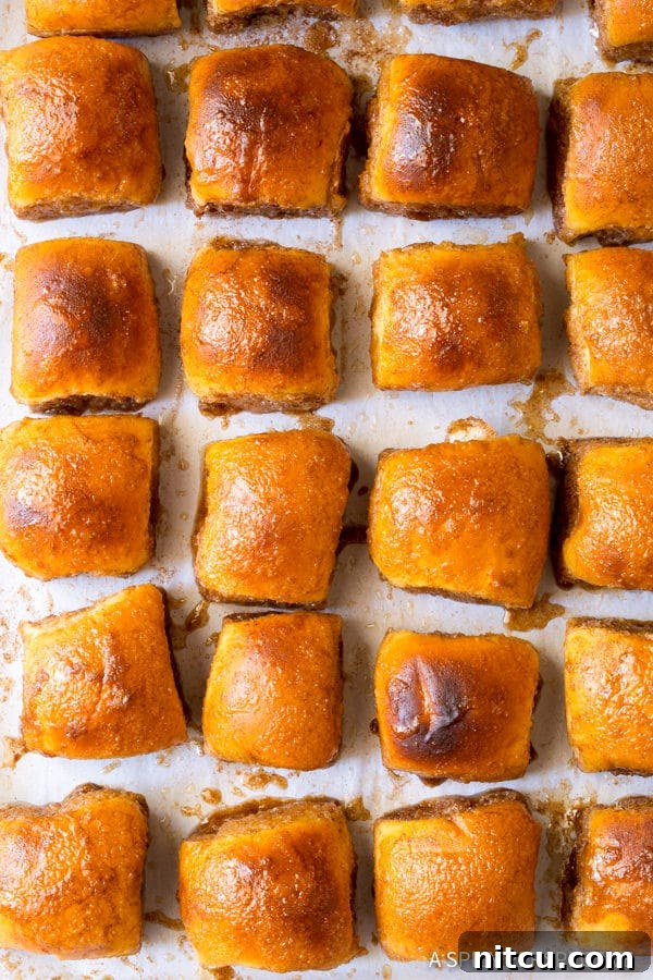 Overhead shot of golden brown 4-Ingredient Cinnamon Toast Buns arranged on a cookie sheet, ready to be devoured.