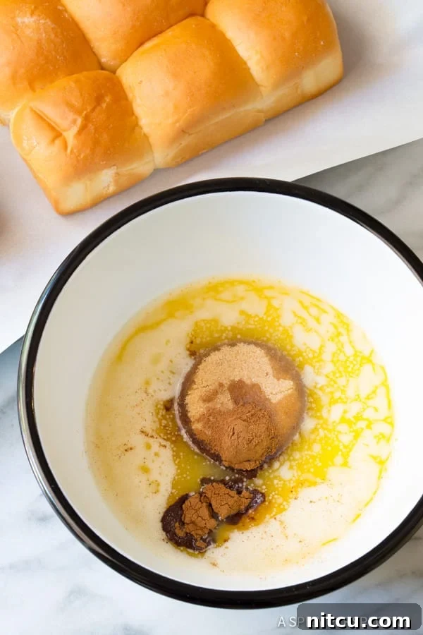 Close-up of the rich, melted cinnamon butter mixture in a bowl, perfect for coating the sugar buns.