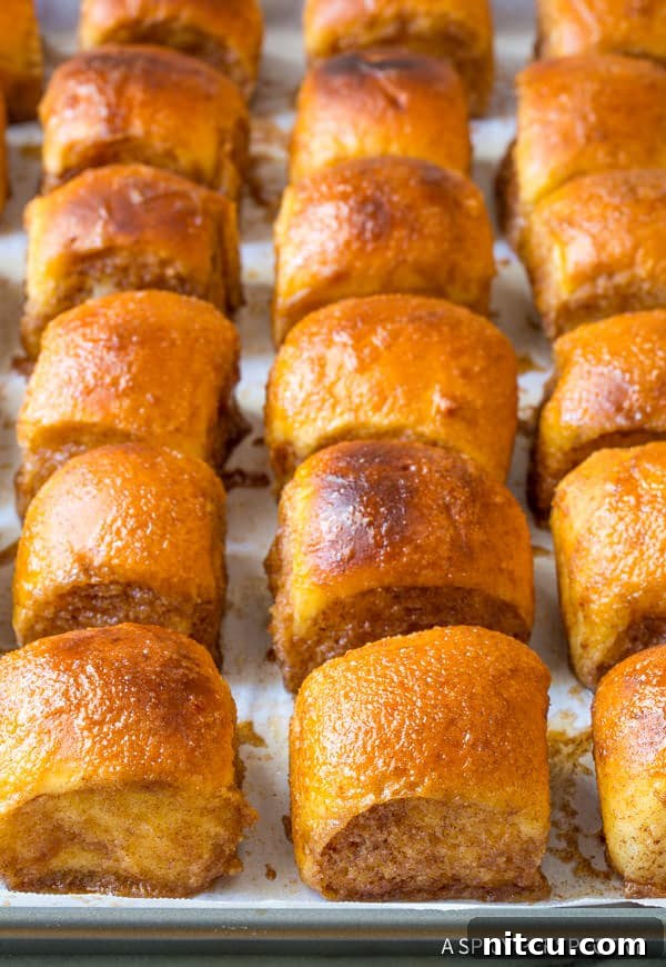 A close-up of 4-Ingredient Cinnamon Sugar Buns, with delicious cinnamon sugar dripping down the sides after baking.
