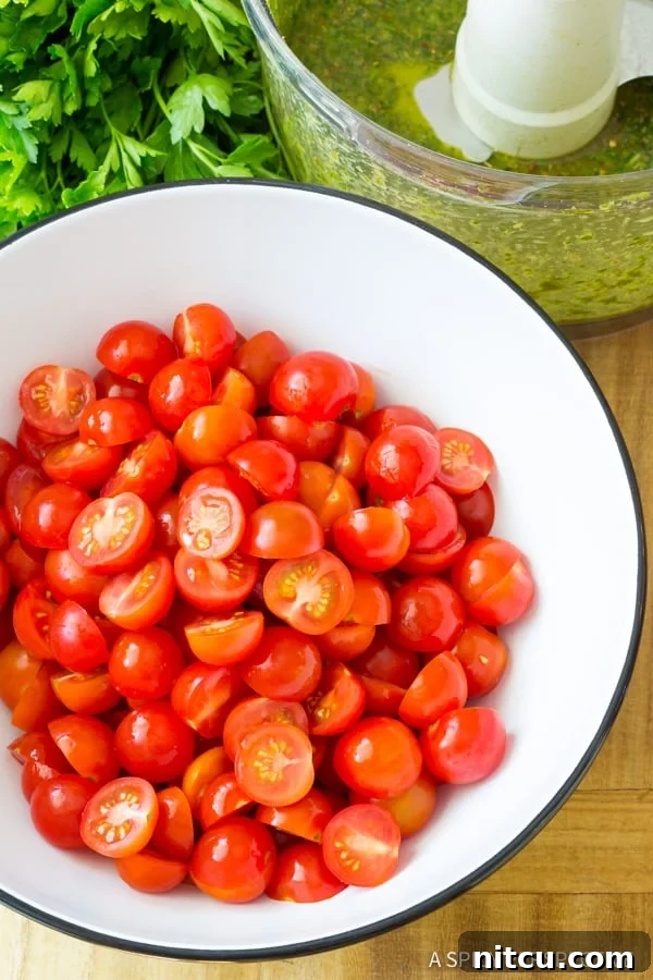 Top down view white bowl with halved cherry tomatoes.