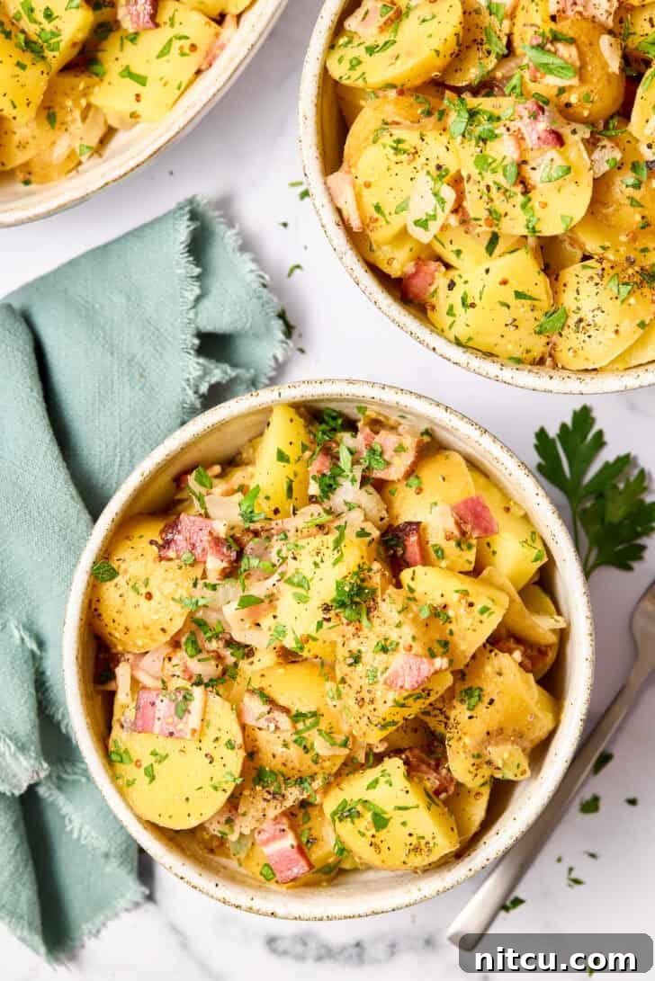 Potato Salad Recipe overhead shot with large and small bowl covered in herbs