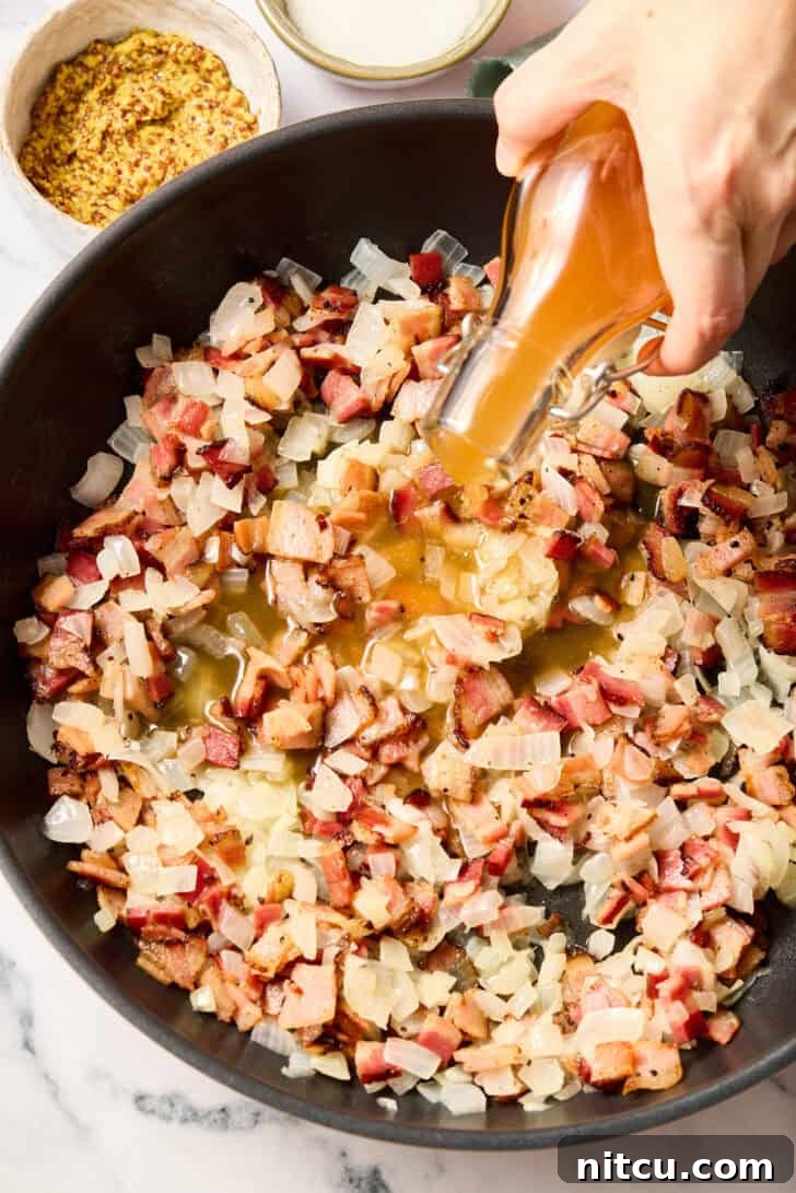 Pouring broth and cooking onions and bacon for warm potato salad