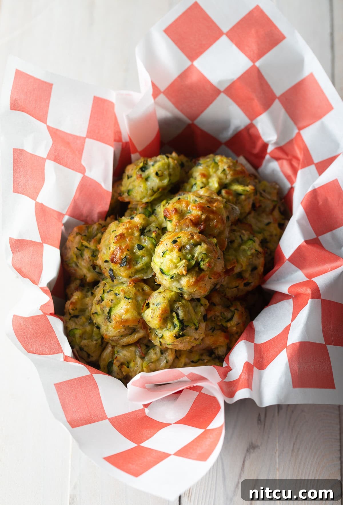 A generous basket overflowing with perfectly baked zucchini tots, highlighting their inviting golden-brown hue.