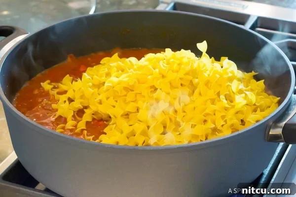 Step 5: Cooked noodles absorbing sauce in the skillet