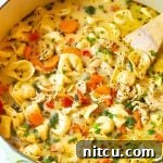 Final chicken tortellini recipe on the stove simmering in low heat