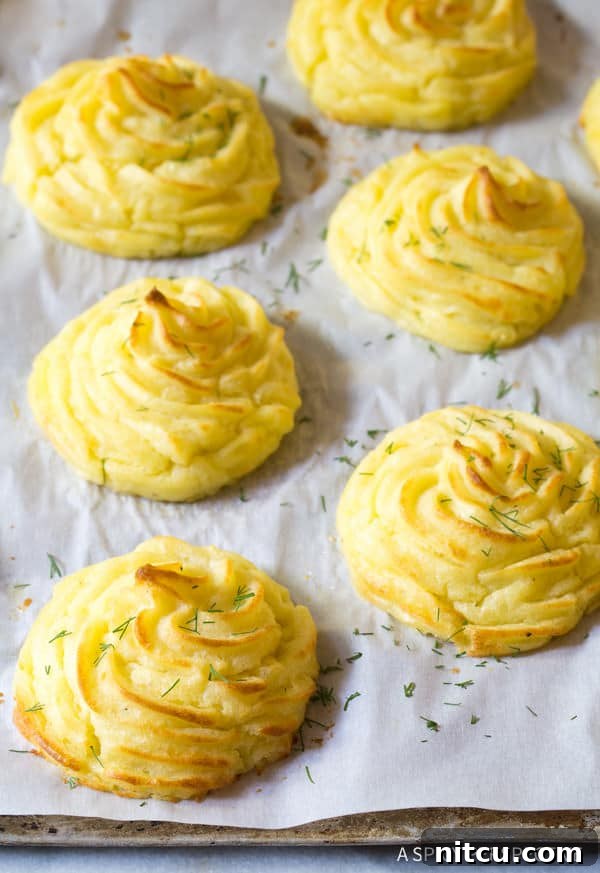 The Best Ever Duchess Potatoes Recipe on baking sheet with chopped herbs