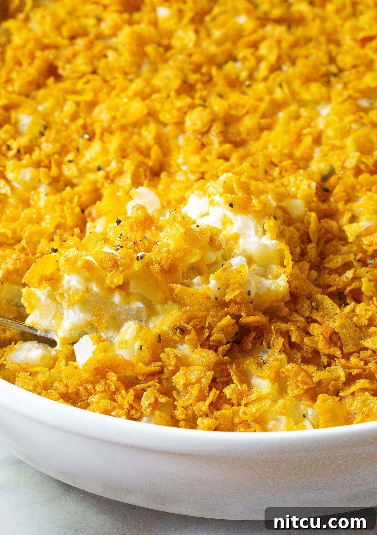 Potato casserole scooped up with serving spoon.