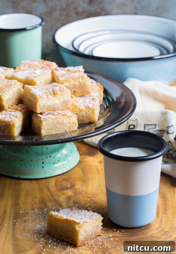 Slice of Ooey Gooey Butter cake with a glass of milk.