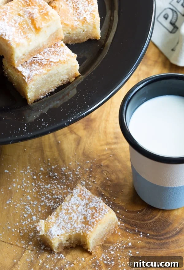 Slice of Gooey Butter Cake with a bite taken accompanied by a glass of milk.