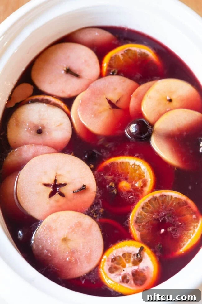 Crockpot Wine Wassail Recipe with fruit floating in the crock