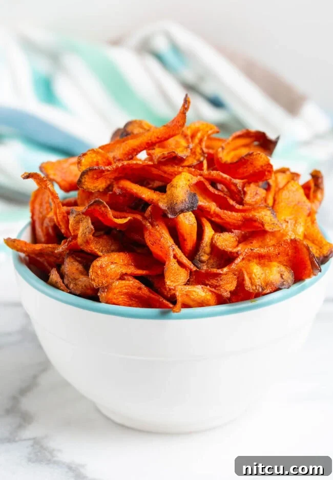 Crispy carrot chips piled high in a bowl, a perfect healthy snack.