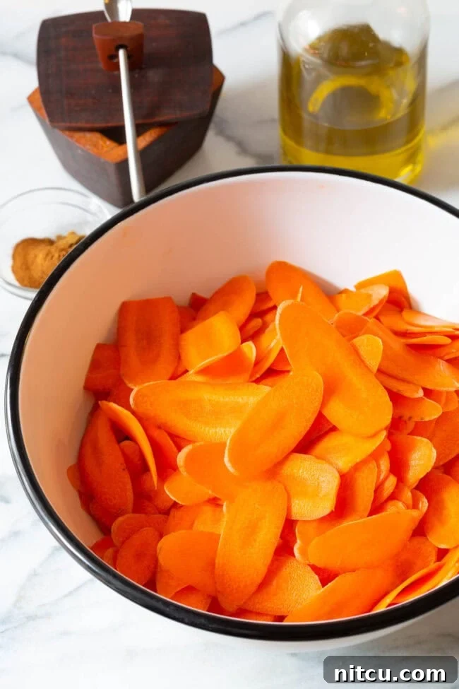 Thin carrot slices perfectly prepped in a bowl, ready for seasoning.