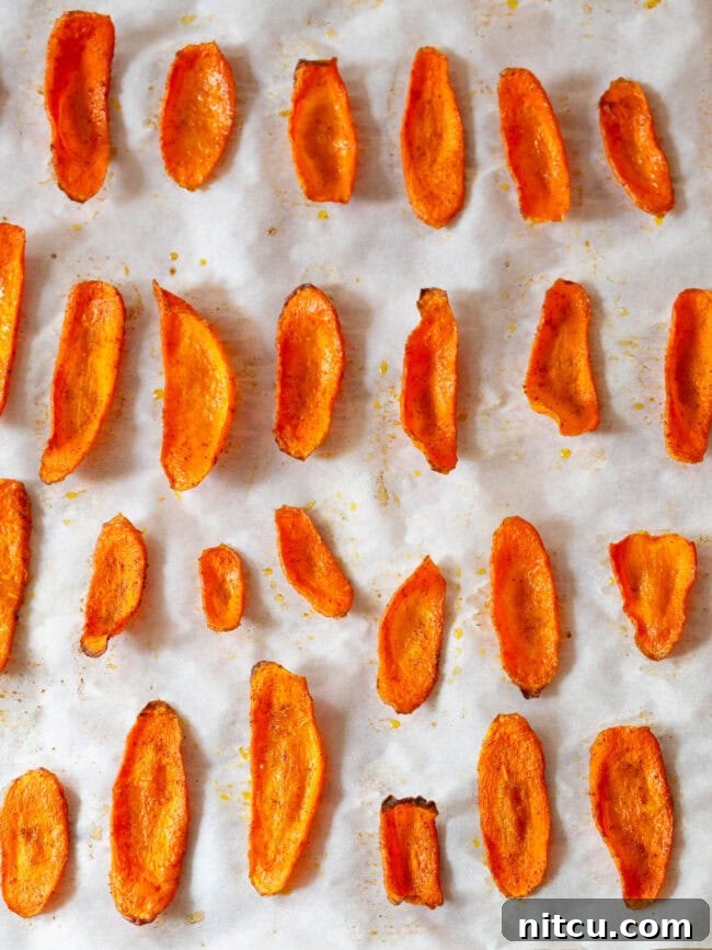 Freshly baked and crispy carrot slices on a baking sheet, ready to enjoy.