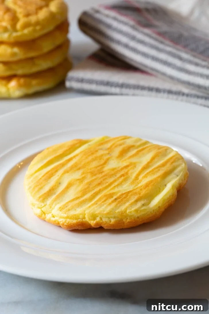 A single piece of golden-brown cloud bread served on a large white plate, ready to be enjoyed.