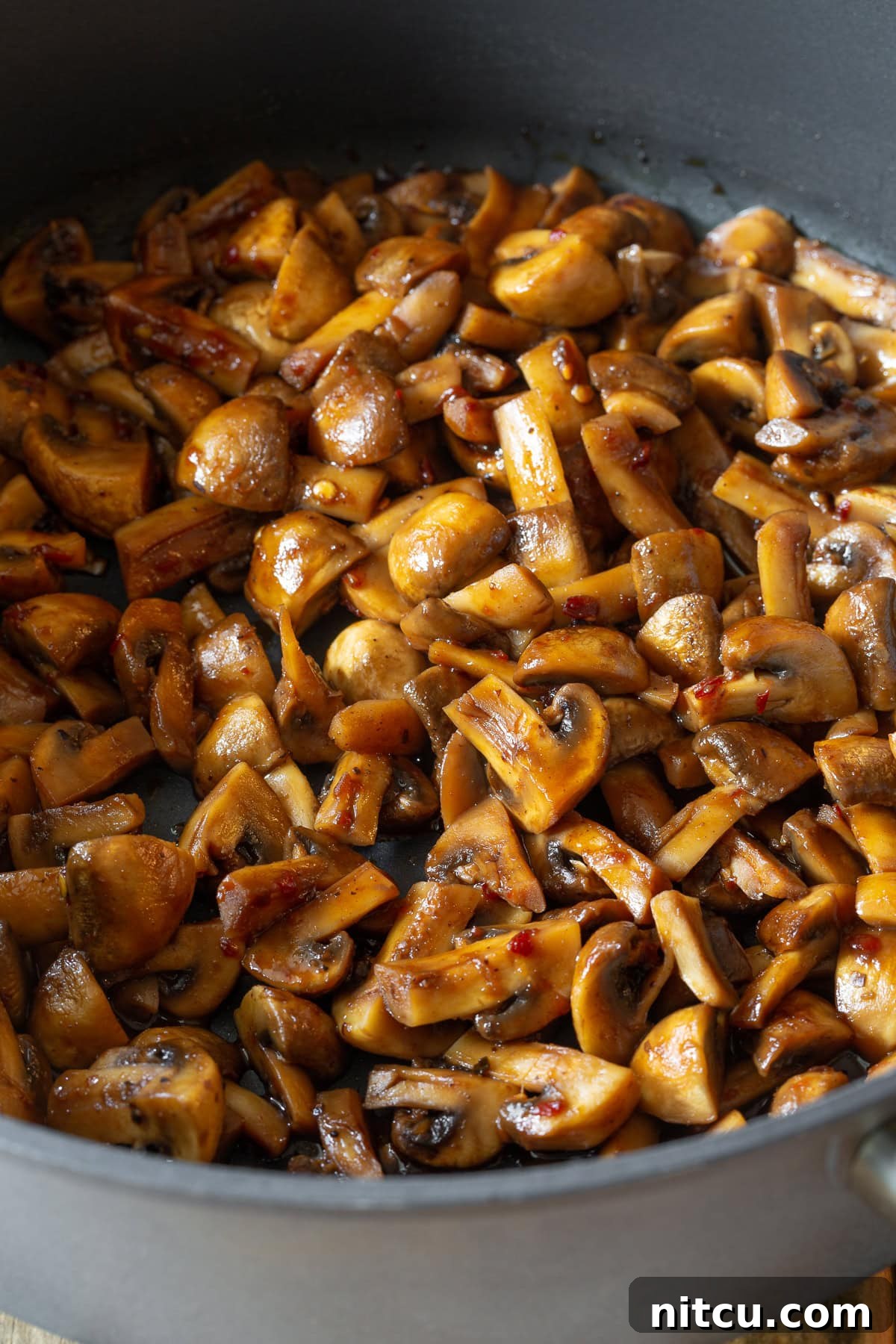 Asian stir-fried mushrooms in a large skillet. 