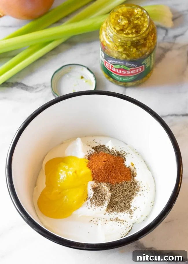 A bowl of creamy yellow potato salad dressing, freshly mixed and ready.