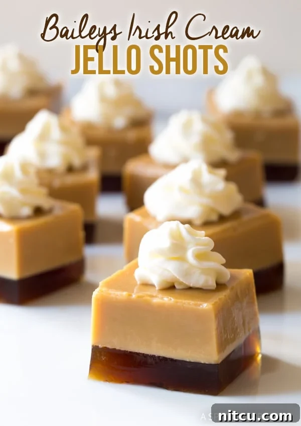 Delightful Baileys Irish Cream Jello Shot squares, beautifully layered and crowned with fresh whipped cream, ready for a St. Patrick's Day celebration.