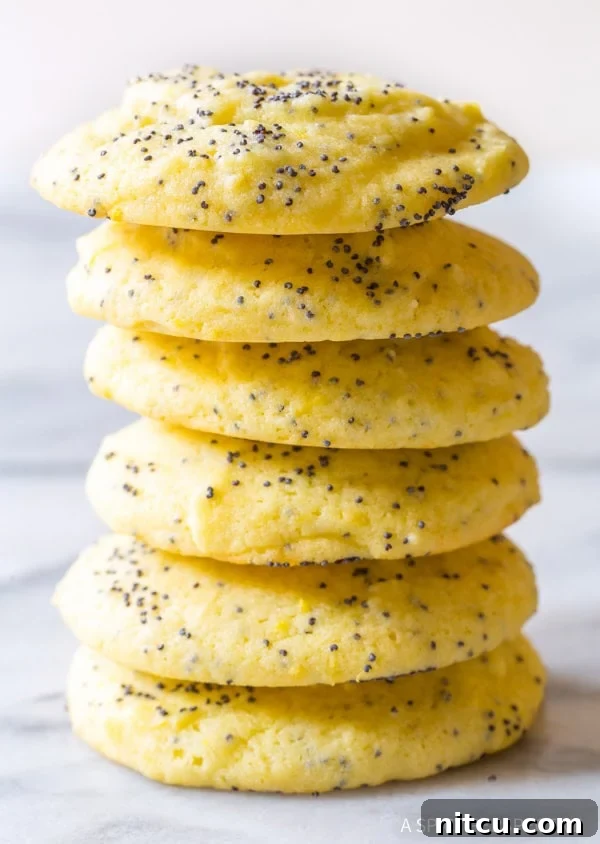 Lemon poppy seed cookies stacked on top of each other, showcasing their soft texture and golden hue.