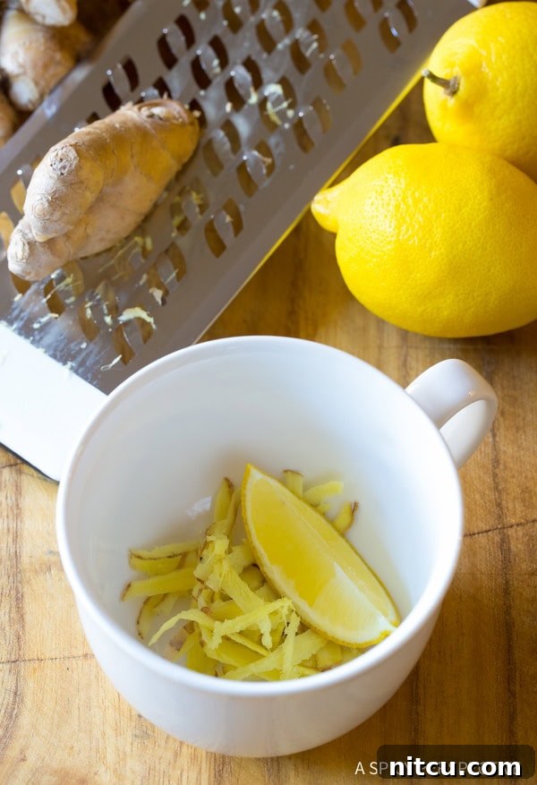 Grated fresh ginger and a bright lemon wedge waiting in a mug, ready for brewing.