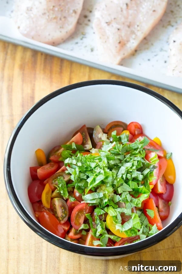 A small rustic bowl filled with quartered grape tomatoes, finely minced garlic, and freshly chopped basil leaves, ready to be mixed for the bruschetta topping.
