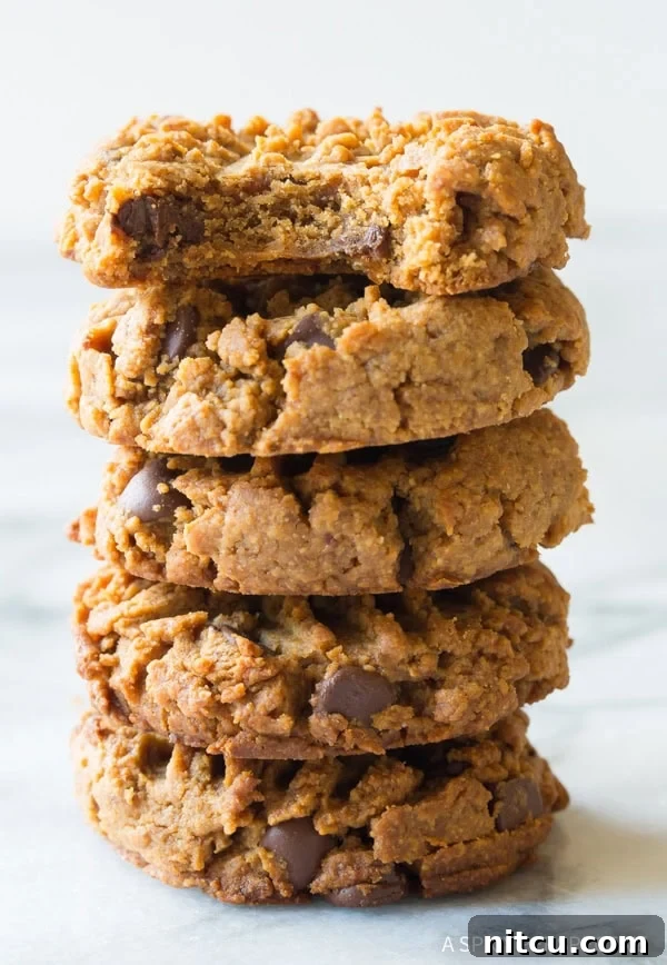 A stack of 6 magic 4-ingredient chocolate chip cookies, with the top peanut butter cookie displaying a perfect bite taken out.