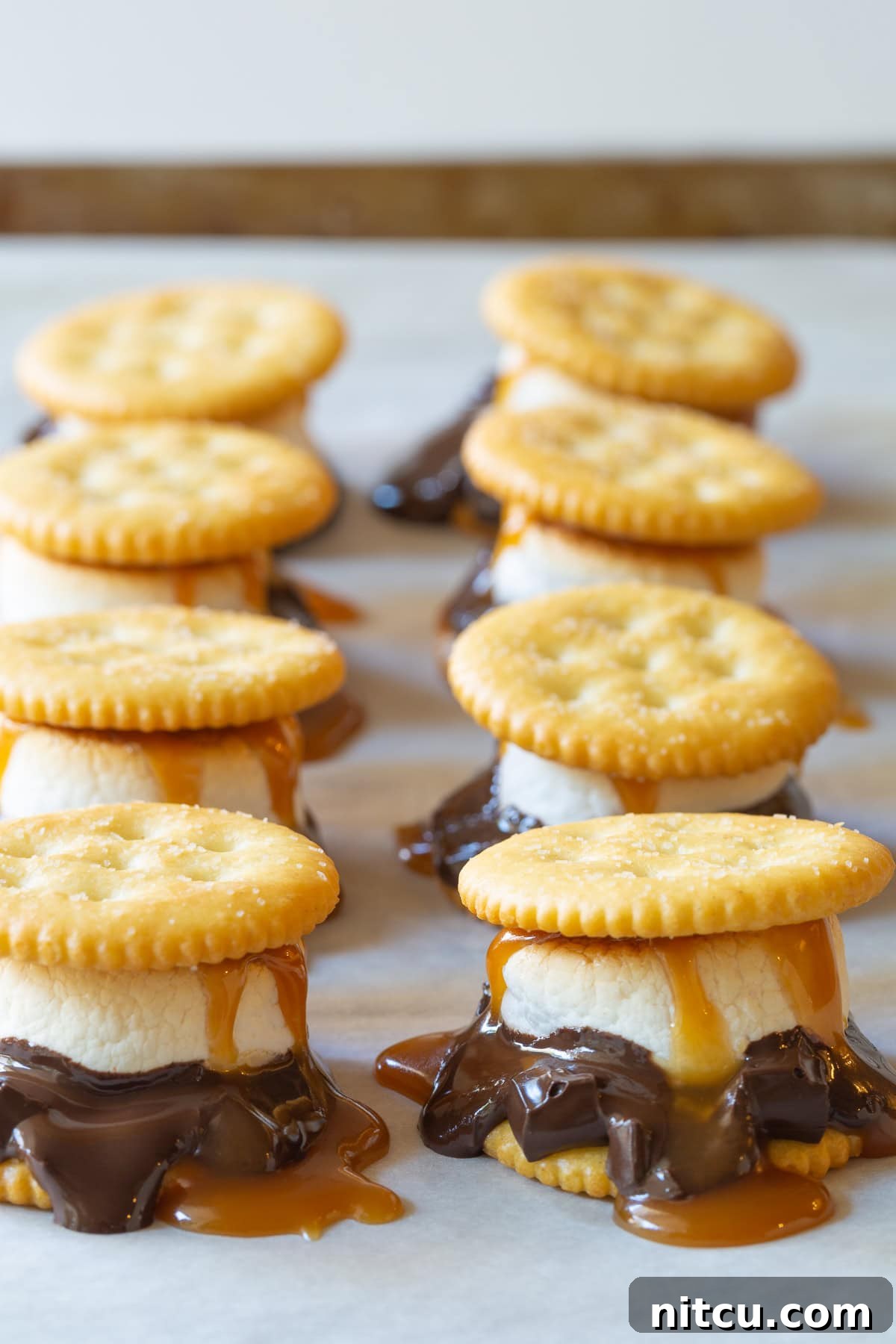 Ritz cracker smores with dark chocolate, marshmallows and salted caramel sauce. 