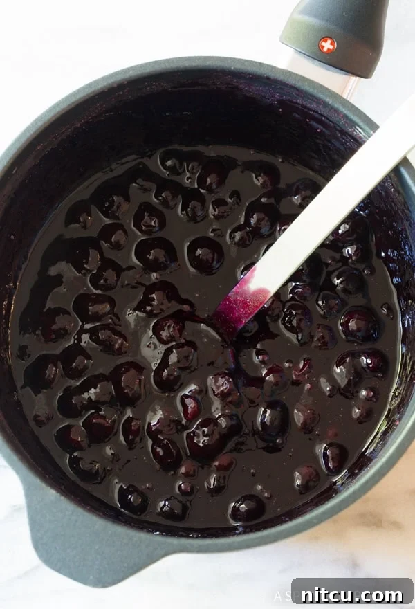 Blueberry sauce simmering in a saucepan.