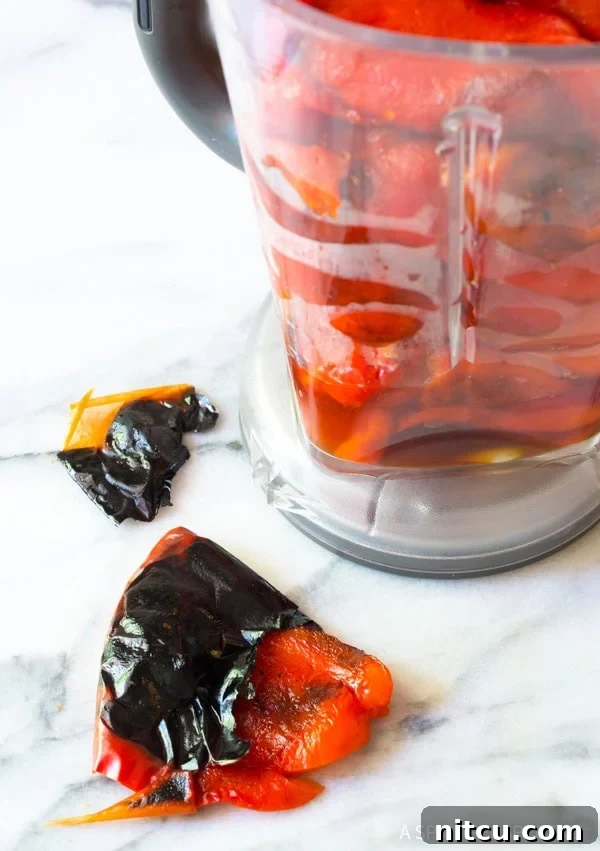Peeling the roasted red peppers and placing them in a blender. 