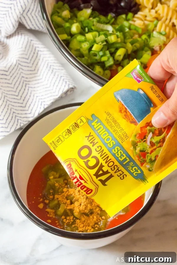 Combining ingredients for Chicken Taco Pasta Salad