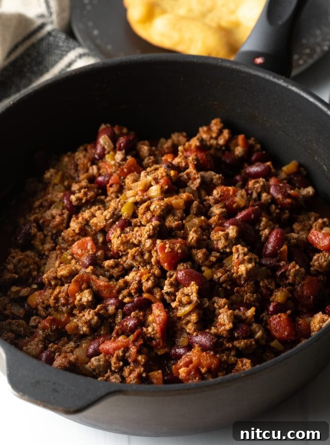Close-up of savory Navajo Taco meat, rich with ground beef, beans, and spices, simmering in a skillet, ready to be served.
