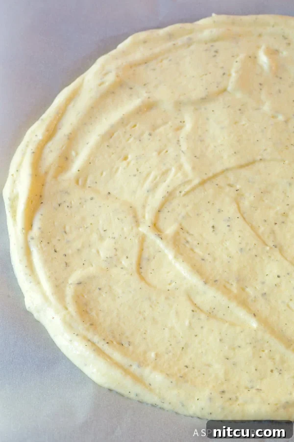 Cloud bread dough spread into a circle on a baking sheet.