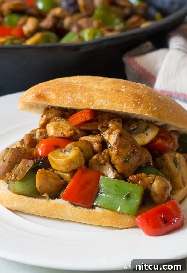 A close-up shot of Croatian chicken and vegetables generously stuffed into a warm, soft sandwich roll.