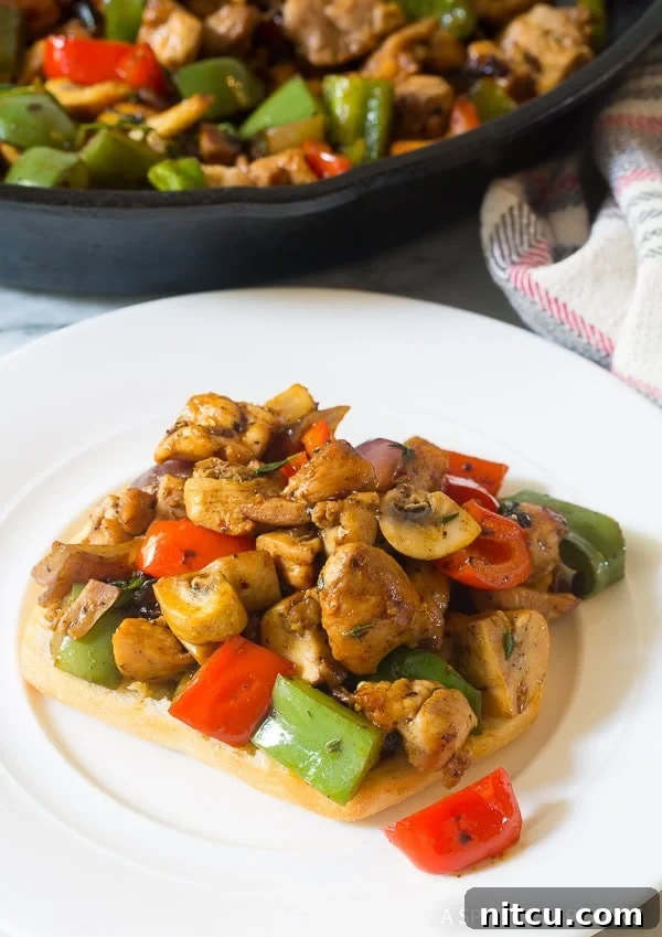 A serving of Croatian chicken and vegetables presented enticingly on a slice of soft, artisanal bread.