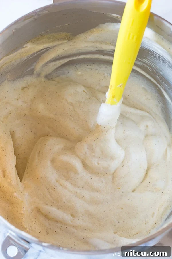 Spatula gently folding batter in a bowl. 