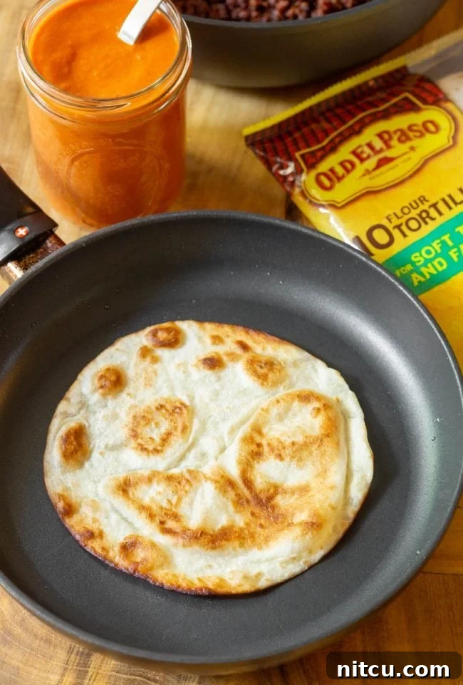 Frying a flour tortilla in a skillet until it puffs up.