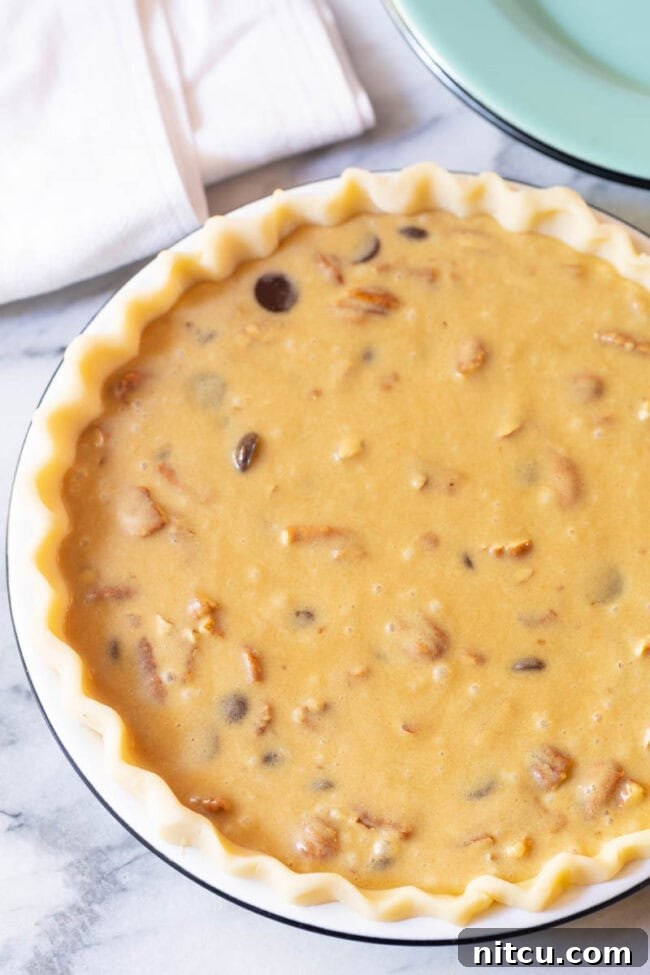 Unbaked chocolate pecan pie filling, rich and inviting, ready for the oven.