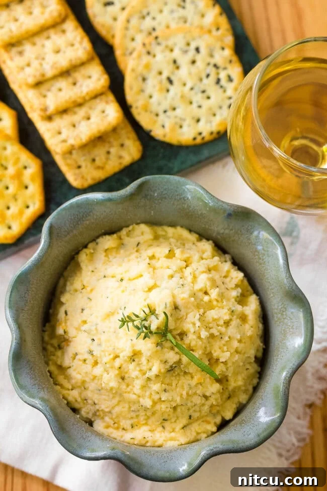 A beautifully textured homemade cheese spread in a rustic white bowl, ready for serving.
