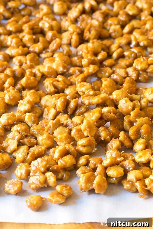 Hardened toffee-coated cracker mixture spread evenly on a baking sheet, cooling down.