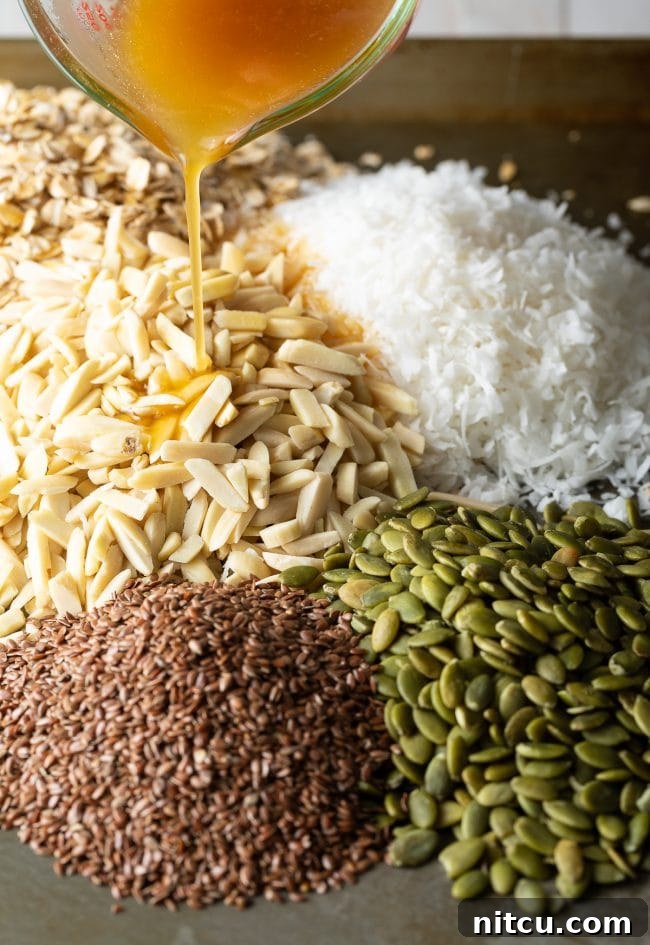 A vibrant mix of seeds, nuts, and dried fruit, drizzled generously with honey before baking.