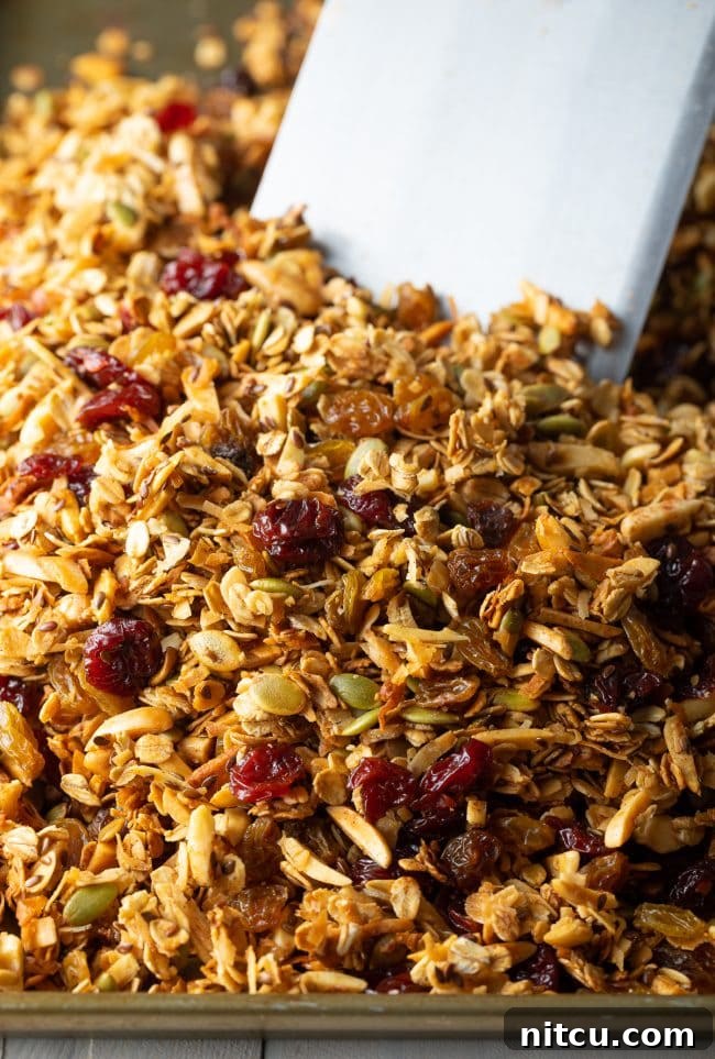 Freshly mixed granola ingredients spread evenly on a baking sheet, ready for the oven.