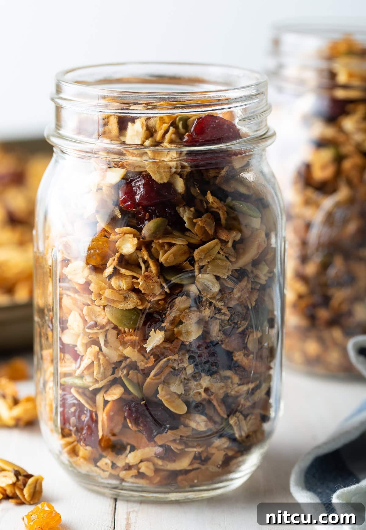 Freshly baked healthy granola cooling on a sheet pan, ready to be stored in a mason jar.