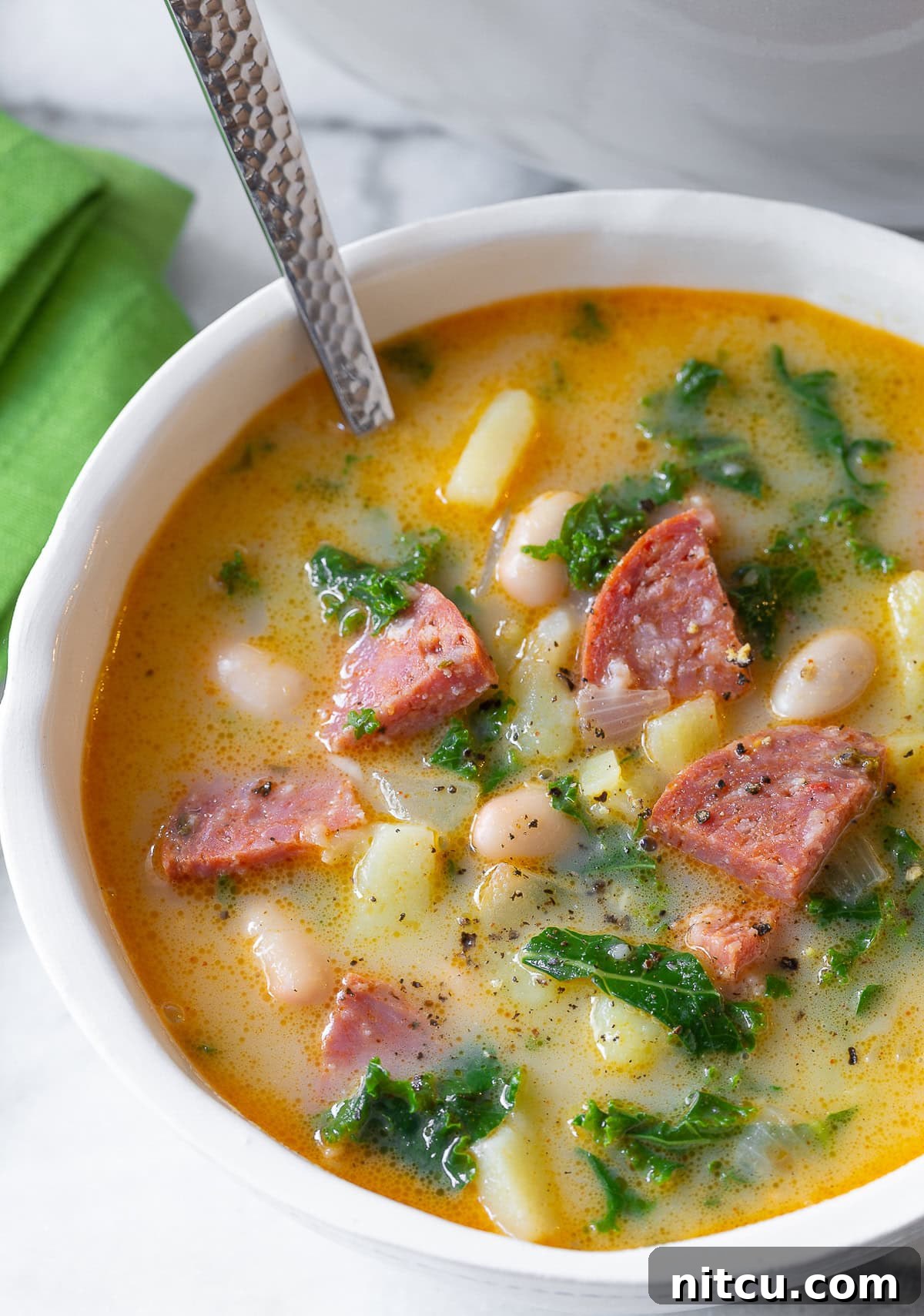A bowl of Caldo Verde, Portuguese soup, with a spoon ready to enjoy.