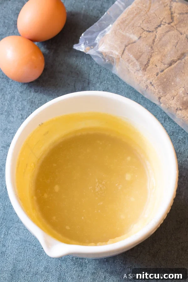 Blended wet ingredients for brown butter cookies in a mixer bowl.